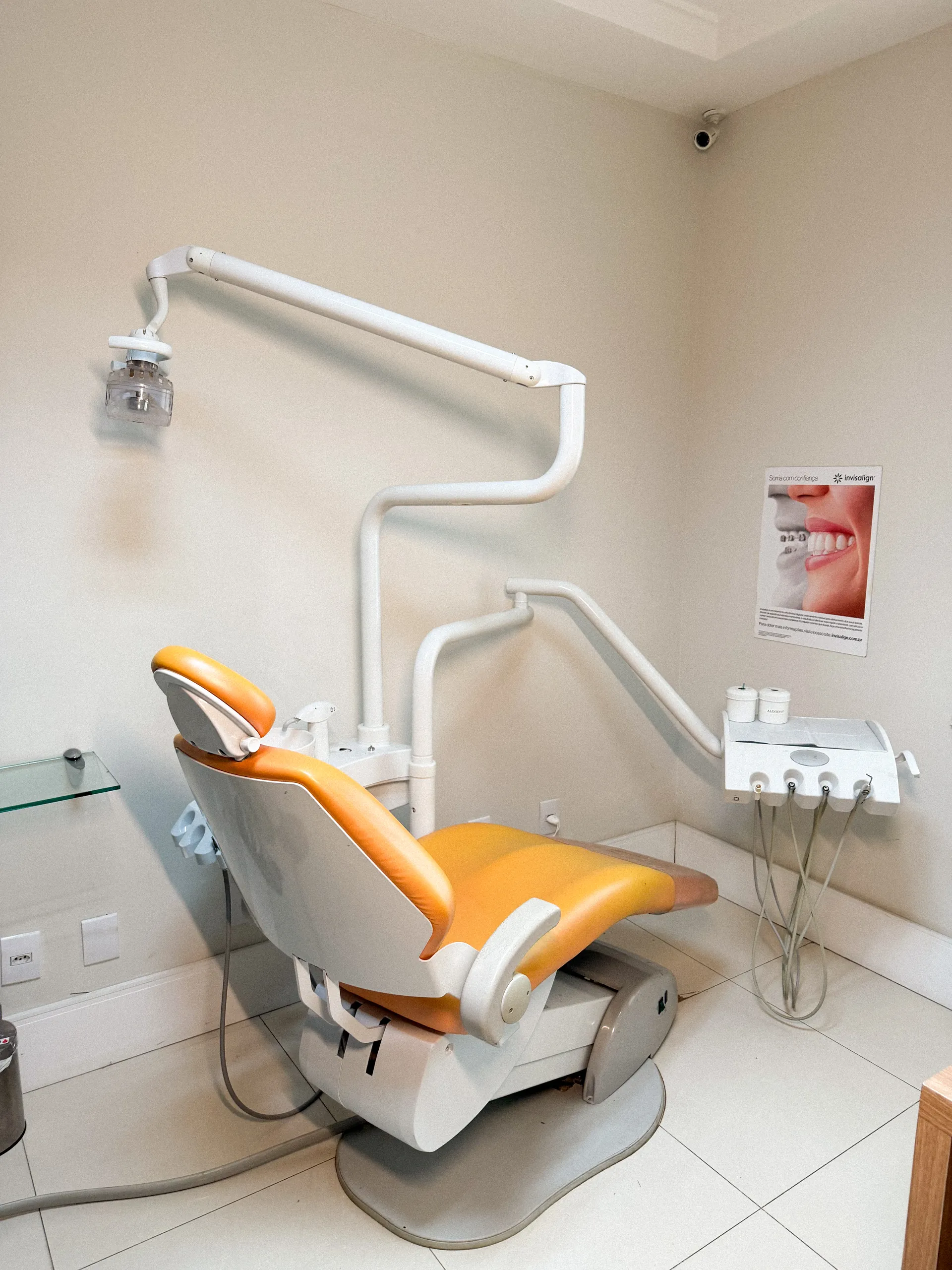 Consultório da OrthoVip com cadeira odontológica laranja e janela ampla