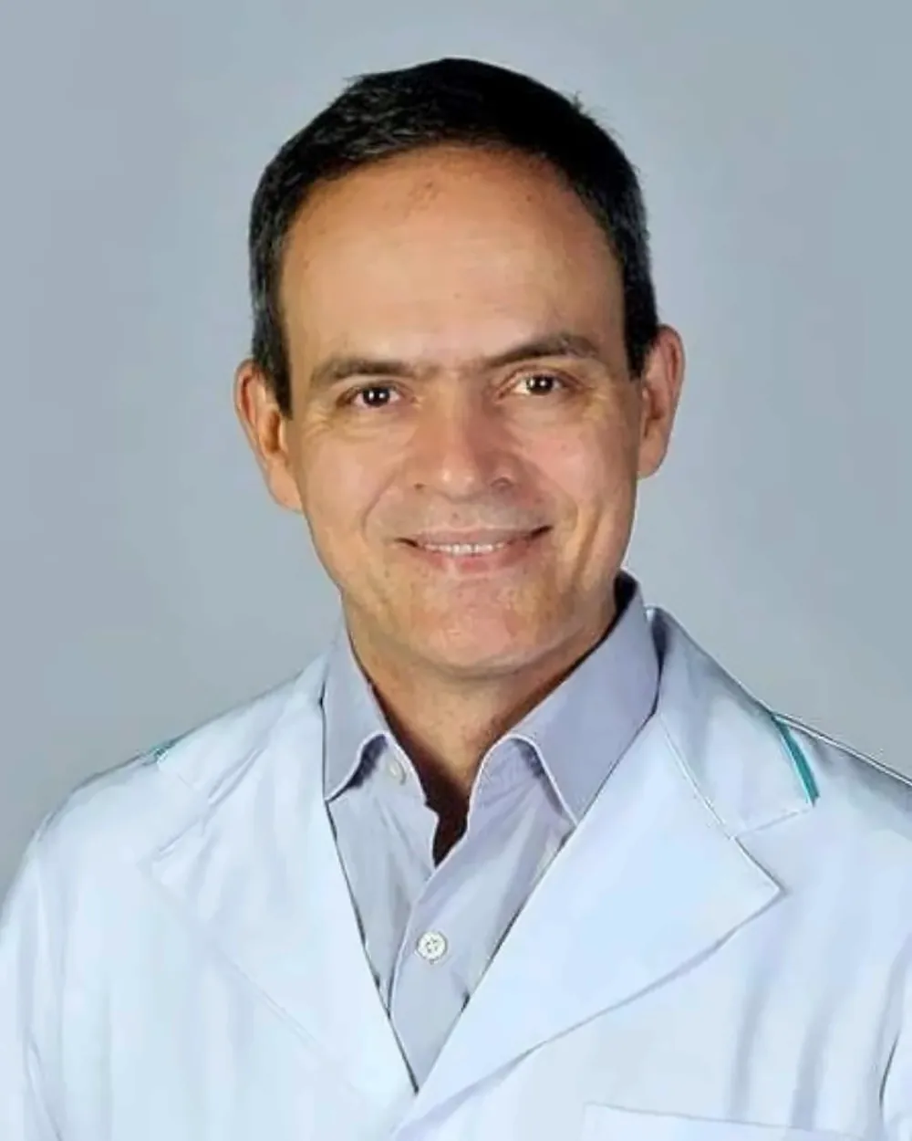 Dr. Marcus Vinícius, implantodontista da OrthoVip, sorrindo de jaleco branco