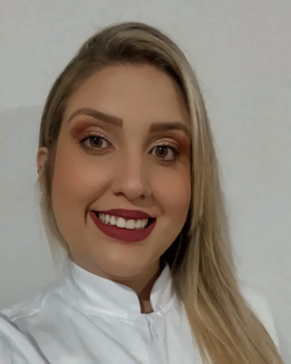 Dra. Stephany, de Cirurgia e Traumatologia Bucomaxilofacial, sorrindo de jaleco branco