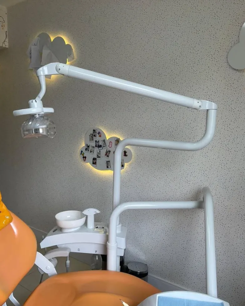 Refletor odontológico e nuvens iluminadas na parede do consultório infantil